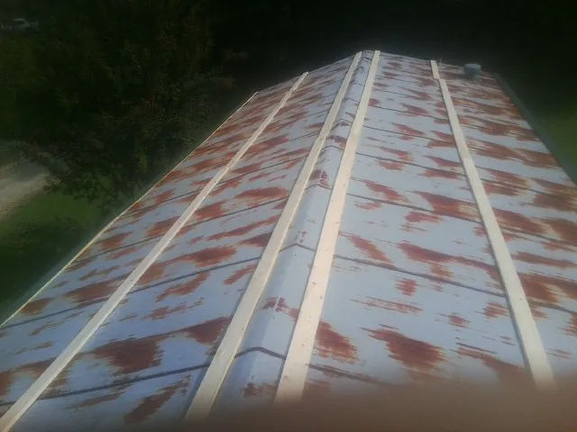 Rusted metal roof panels with new wood purlins before replacement — Storm Damage Roof Repair in Dickinson by Roofing Brothers
