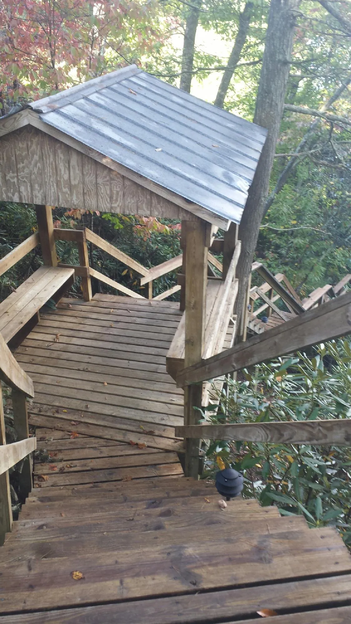 Metal roofed shelter over wooden steps on a wooded walkway — Skylight Repair & Installation work by our crew in Dickinson